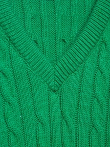 Close-up of grass green V-neck knitted sweater featuring thick cable knit texture