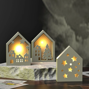 Détail de veilleuses en forme de maison évidée avec des motifs festifs lumineux