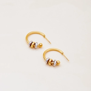 Close-up of gold stainless steel hoop earrings with alternating gold and silver beads