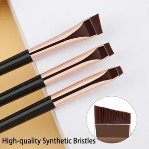 Three angled eyeliner and eyebrow brushes with rose gold ferrules on a minimalist base