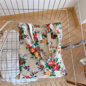 Gros plan sur un cabas en toile à fleurs avec imprimé rose rétro dans un chariot