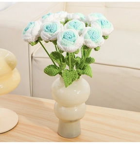 Handcrafted crochet roses in mint green and white displayed in a beige ceramic vase