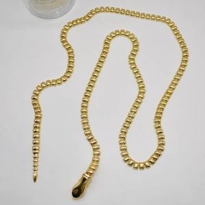 Macro detail of golden metal snake chain link texture and smooth head buckle design