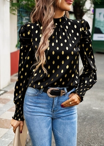 Detail of black puff sleeve blouse with gold polka dots and cuffed wrist design