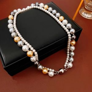 Détail d'un collier de perles multicouches avec fermoir magnétique sur boîte en cuir noir