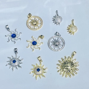 Selection of gold and silver sun-shaped pendants with inlaid cubic zirconia and blue gems