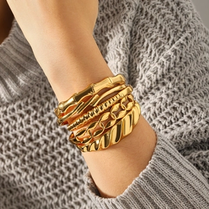 5-piece stackable 18k gold plated titanium steel bangles set worn by a model