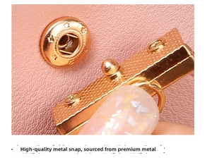 Macro detail of star-embossed golden snap fastener on pink faux leather long wallet