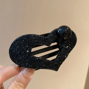 Close-up of black heart hair claw with sparkling crystals and large pearl detail