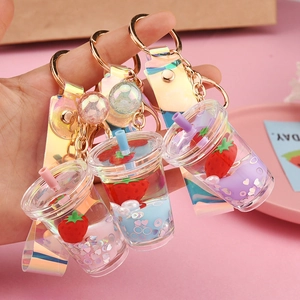 Creative strawberry milk tea cup keychains in pink, blue, and purple liquid styles