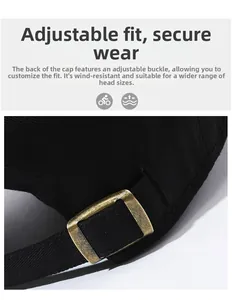 Detail of black baseball cap showing the adjustable bronze metal buckle and stitching