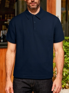 Détail du polo en tricot gaufré bleu foncé avec col boutonné et tissu texturé doux