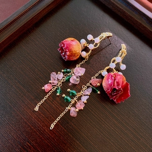 Detail of rose pearl earrings with pink stone tassels and a vintage gold finish
