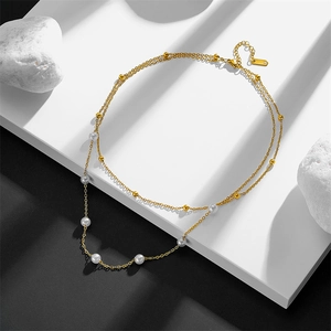 Double-layer stainless steel gold necklace with white pearls on a geometric background