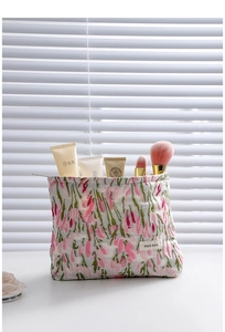 Close-up of floral fabric makeup bag with brushes and skincare tools in soft light