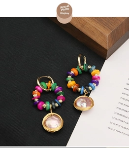 Detail of bohemian colorful beaded hoop earrings with gold-wrapped pink baroque pearls