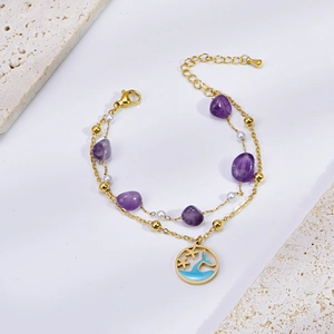 Detail of gold starfish anklet with purple natural stone and ocean wave round charm