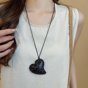 Detail of a leopard print heart pendant on a minimal black cord necklace for women
