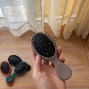 Mini spazzola per capelli portatile con cuscino d'aria massaggiante in rosa chiaro