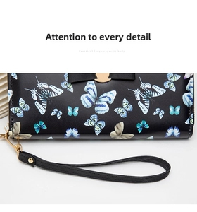 Detail of floral butterfly print on long wallet with golden buckle and black ribbon