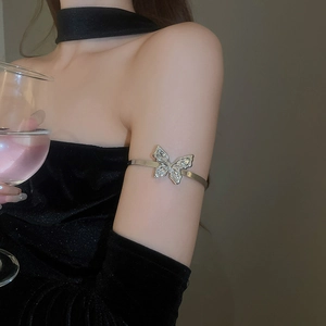 Close-up of a sparkling silver butterfly upper arm cuff with rhinestones on a model