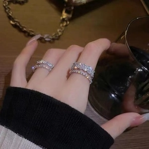 Close-up of stacked silver rings with shimmering zircon stones and twisted metal design