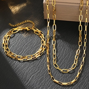 Golden paperclip link chain necklace and bracelet set displayed on a jewelry box