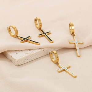 Detail of gold cross hoop earrings with black and white zircon stone inlay for a stylish look