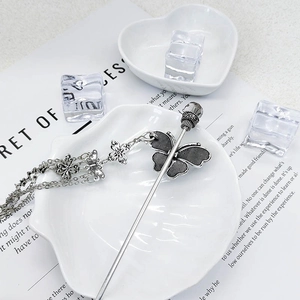 Gros plan détaillé du pic à cheveux papillon argent antique avec pompons en cristal sur porcelaine