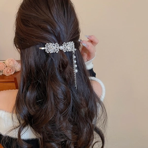 Detail of square fringe pearl hair clip with rhinestones worn on wavy hair