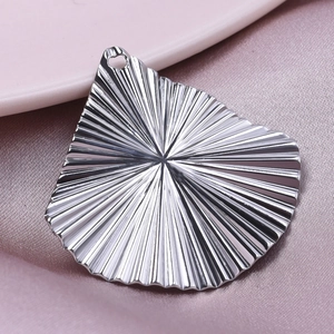 Detailed view of silver stainless steel fan-shaped pendant with sunburst texture