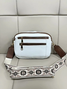 Detail of white PU crossbody bag with brown trim and floral embroidered wide strap