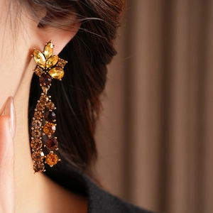 Detailansicht von Vintage-Blumenohrringen mit bernsteinfarbenen Steinen am Modell
