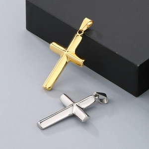 Detailed view of polished gold and silver cross pendants on a gray background