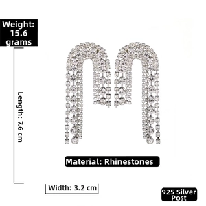 Detailed view of silver asymmetric U-shaped earrings with rhinestones, 7.6cm length