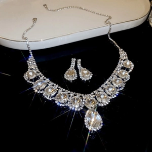Gros plan sur une parure de bijoux en strass argentés avec collier et boucles d'oreilles
