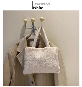 Close-up of white plush lamb wool tote bag texture against a beige winter coat