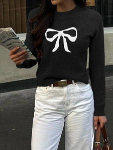 Detail of a casual black short-sleeve knit sweater featuring a white bow print pattern