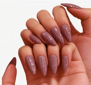 Gros plan sur des faux ongles brillants couleur rose poudré, forme amande au fini élégant