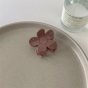 Détail d'une pince à cheveux fleur en acétate rose avec gravure faite main sur pétales