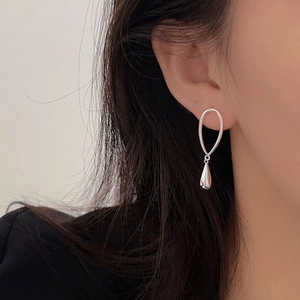 Close-up of elegant S925 sterling silver oval ring and teardrop drop earrings on model