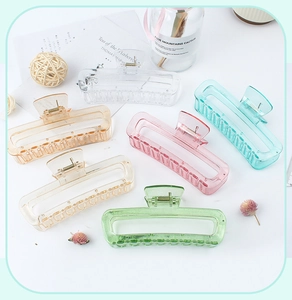 Multiple colorful transparent hollow square hair claws displayed on a white table