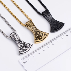 Three Viking axe pendants in silver gold and black with a ruler showing size details