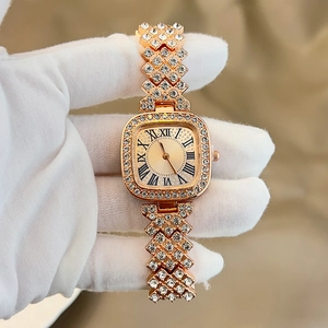 Macro detail of luxury gold square watch with crystal rhinestones and roman dial scale
