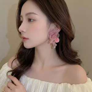 Elegant mesh flower earrings with plush pompoms worn by a model in a romantic style
