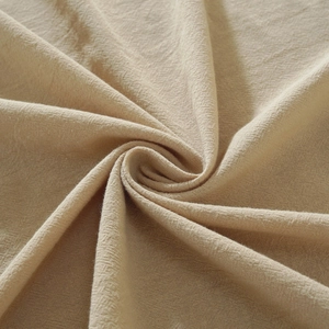 Macro view of beige cotton linen fabric texture with elegant spiral fold pattern