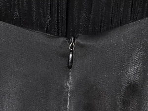 Détail du dos d'une combinaison dos nu noire à paillettes avec satin plissé et fermeture