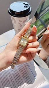 Detailed close-up of a square crystal-encrusted quartz watch with two-tone metal band
