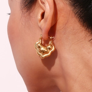 Elegant 18K gold-plated stainless steel hollow lotus hoop earrings for women on model
