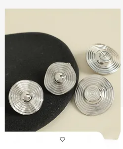 Detail of silver round earrings with concentric ripples and retro minimalist design